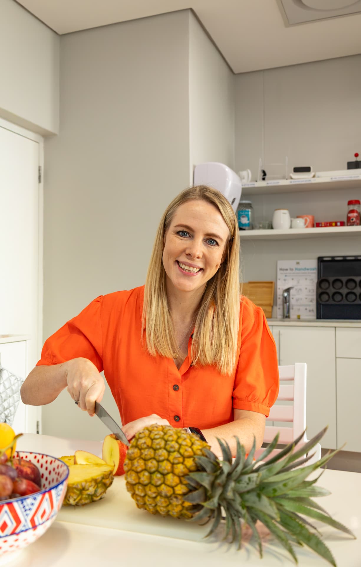 Michelle Tolmay, registered dietitian, slicing fresh fruit in a clinic kitchen
